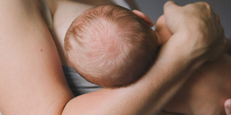 Женщина дает малышу грудь